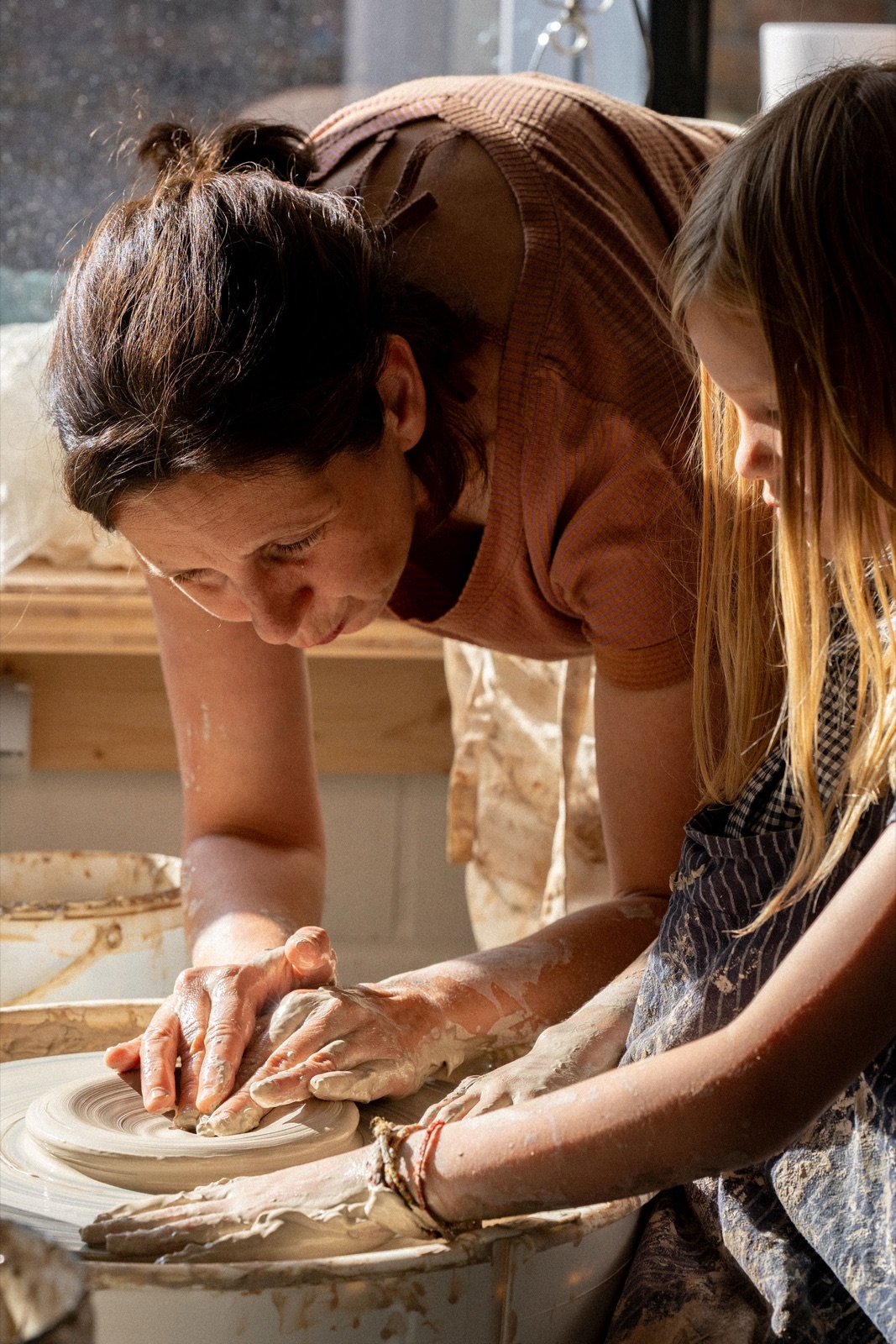 Eva helpt een deelnemer aan de draaischijf in het atelier
